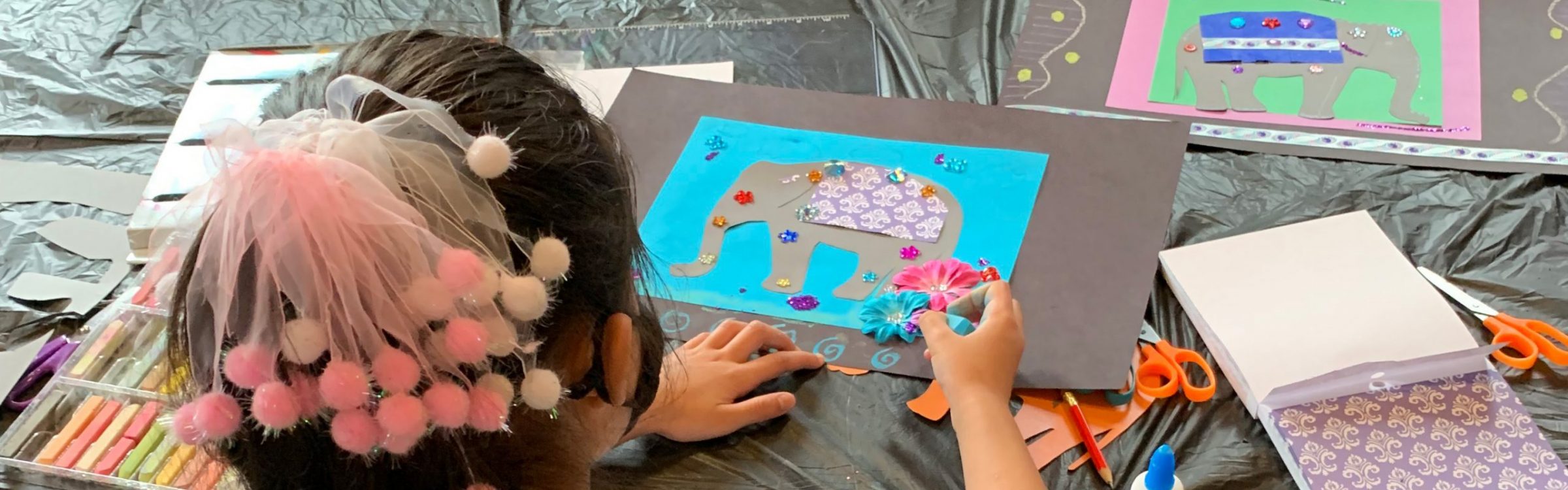 Image of a child creating a collage of an elephant.