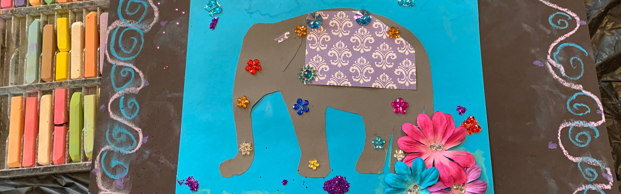 Collage featuring an elephant on bright blue paper surrounded by art supplies
