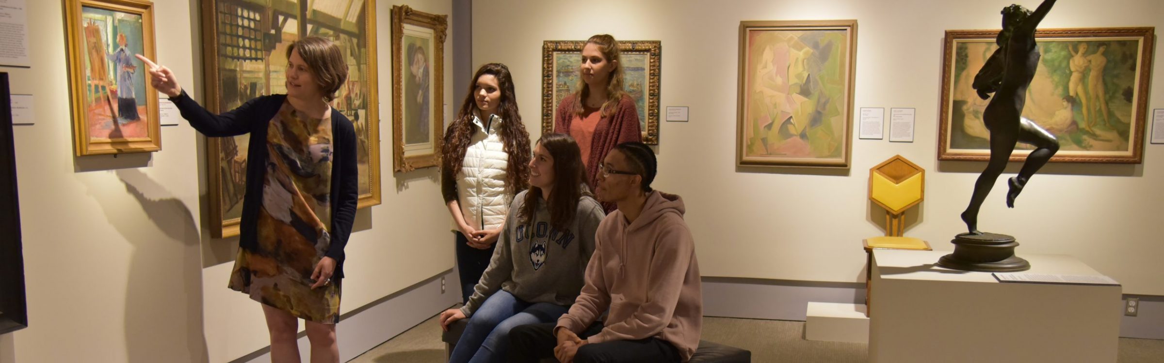 Image of a group of students looking at paintings.